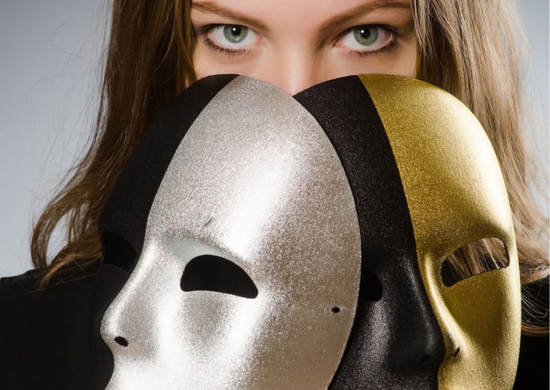 Une femme avec 2 masques, symbole du syndrome de l’imposteur